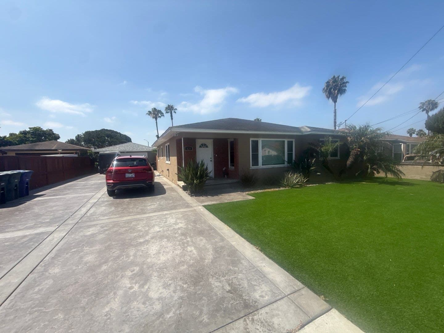 The single-story main house at 429 Naples Street, with its front lawn and driveway.