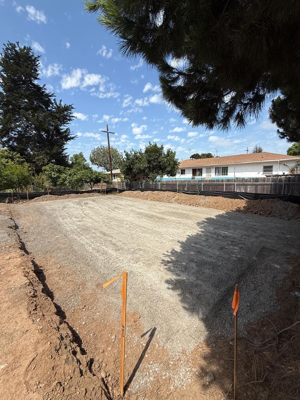 A graded, staked building pad at 452 Naples Street.