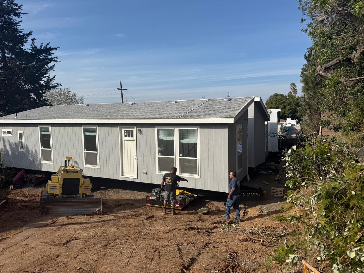 A new manufactured home being set on its foundation at 452 Naples Street, with the crew on site.