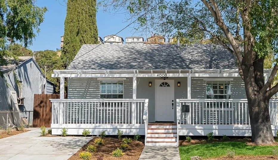 The finished house at 4003 Paula Street: light grey siding, a white front porch and new landscaping.
